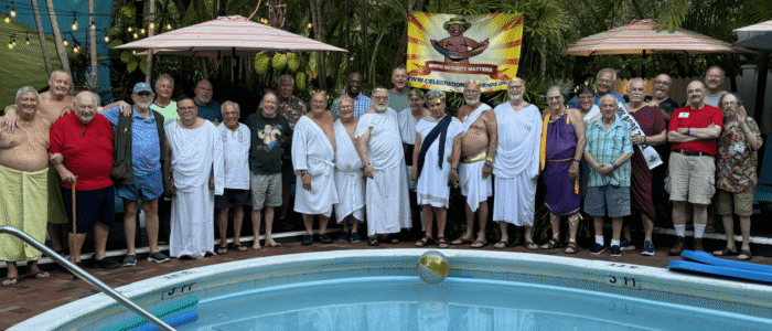 A group of men in robes standing around a pool.